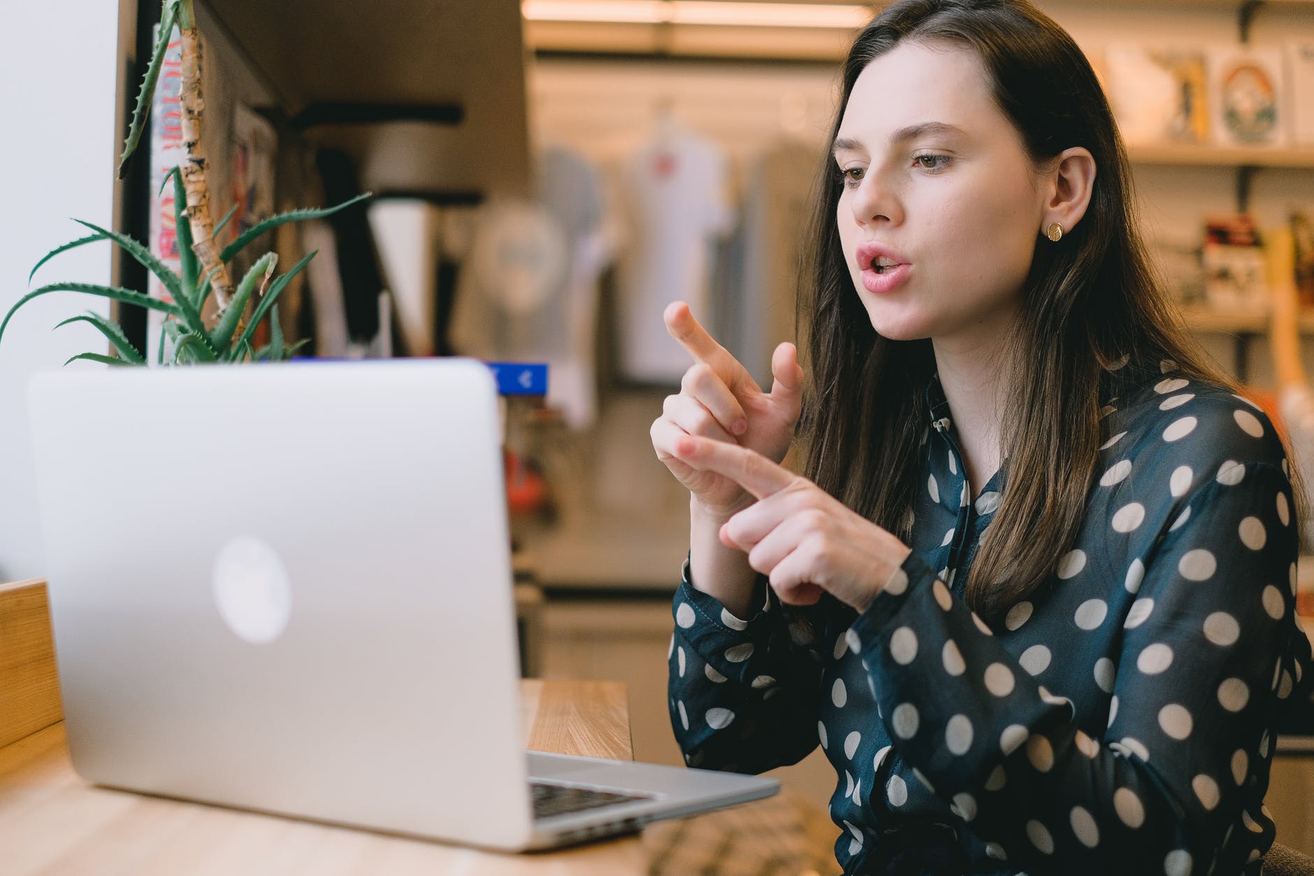 focused young woman having video call on netbook in modern workspace